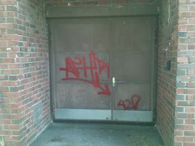 punaisella graffititägillä töhritty ovi