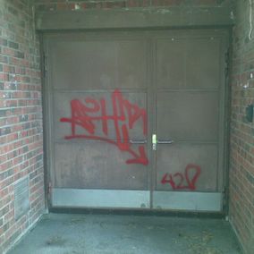 punaisella graffititägillä töhritty ovi